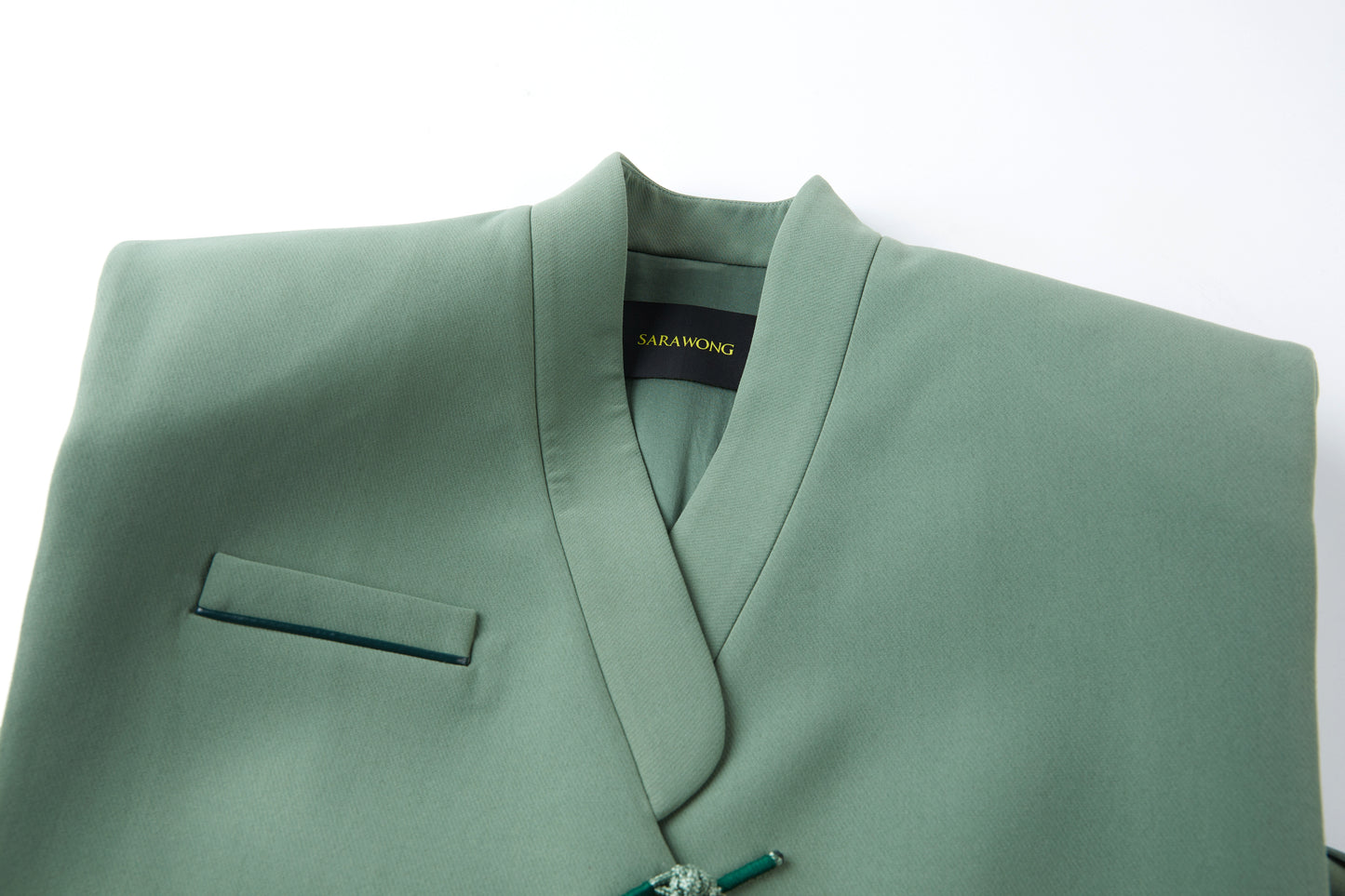 Celadon sleeveless suit with cutaway buttons