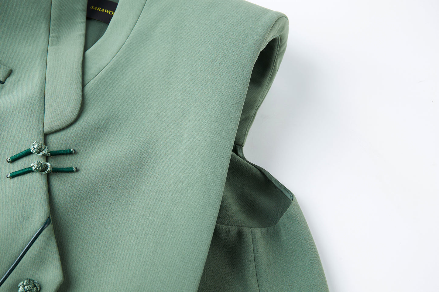 Celadon sleeveless suit with cutaway buttons